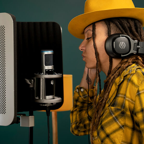 Woman using the Sterling ST155 large diaphragm condenser microphone in studio.