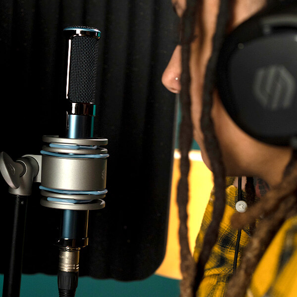 A woman singing into Sterling ST170 active ribbon microphone in the studio.