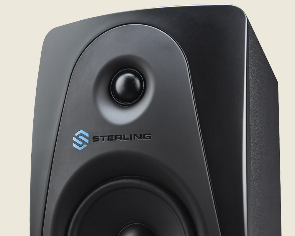 Sterling MX5 5-inch powered studio monitor left on light background.