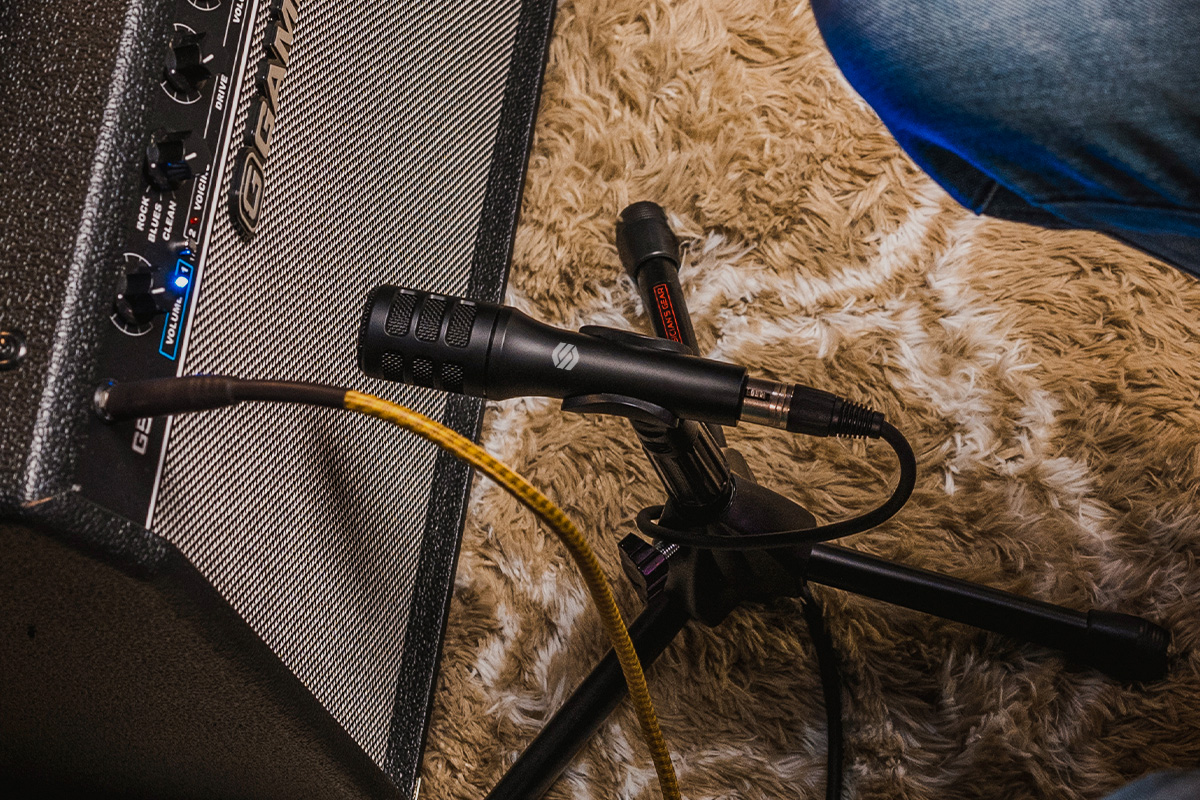 Sterling P10 instrument microphone in studio with amplifier and guitarist close up.