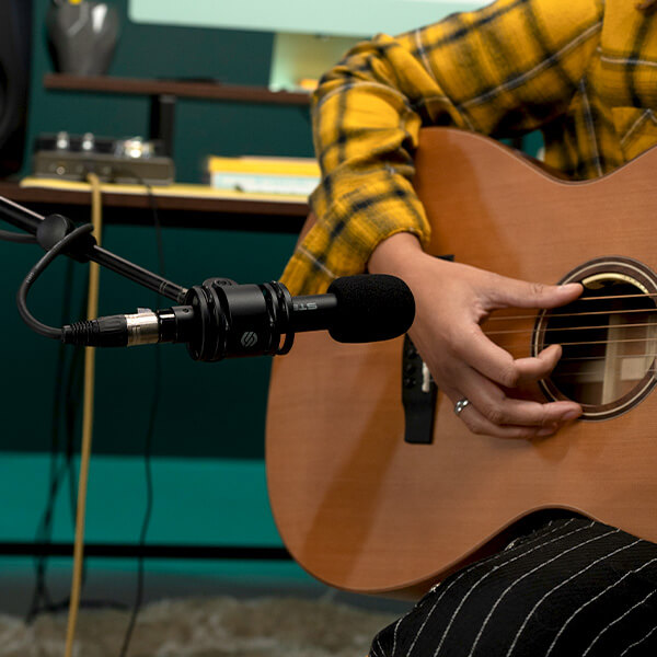 Sterling SL230MP Condenser Microphone recording person with guitar in studio.