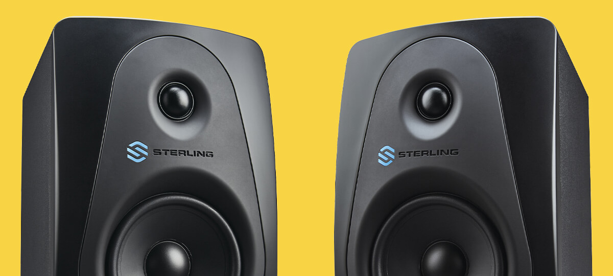 Sterling MX5 5-inch powered studio monitor right and left close up on yellow background.