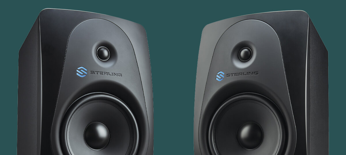 Sterling MX8 8-inch powered studio monitor right and left close up on green background.