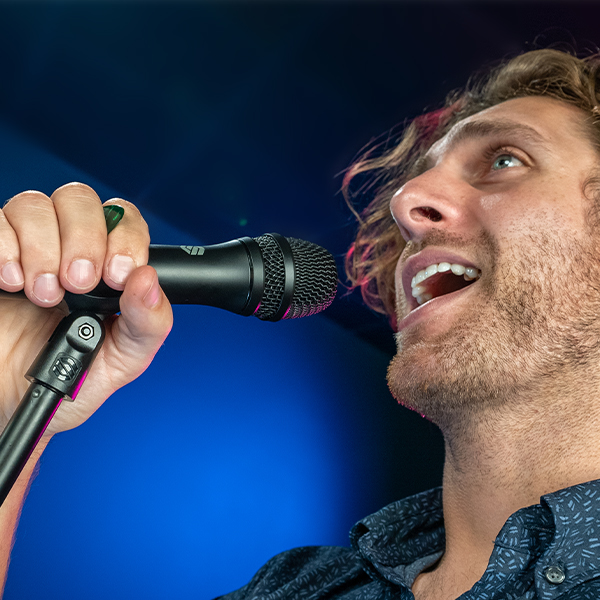 Man singing into Sterling P20 live vocal microphone on stage close up.