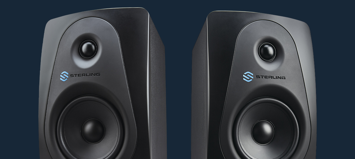 Sterling MX5 5-inch powered studio monitors pair on blue background.