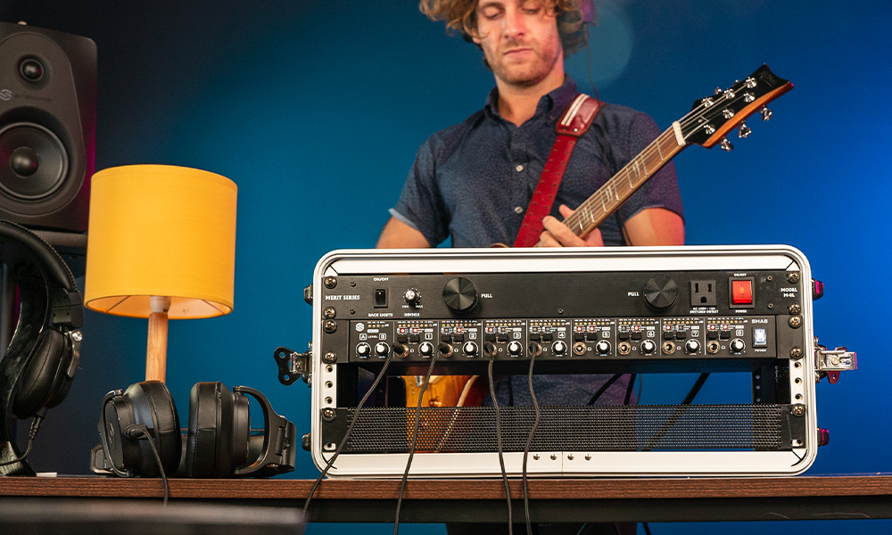 Sterling SHA8 8-channel rackmount headphone amplifier in a studio with guitar player.