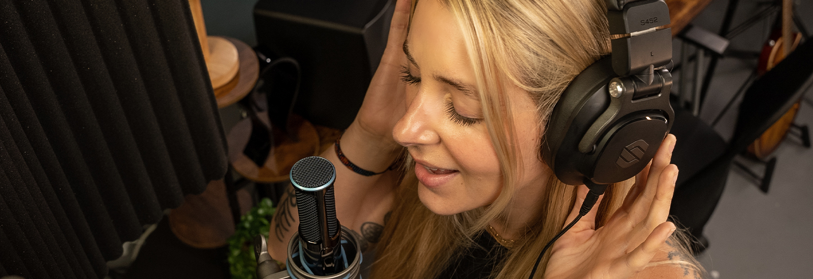 Singer recording with Sterling S452 studio headphones in studio.